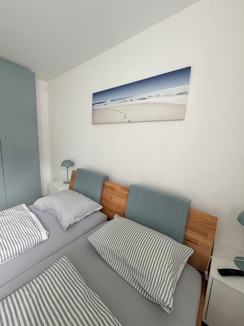Frisch bezogenes Doppelbett mit gestreifter Bettwäsche