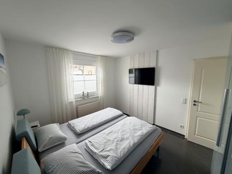 Schlafzimmer mit Doppelbett und Flachbildfernseher