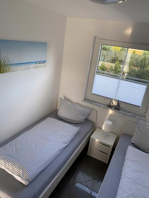 Einzelbetten mit Nachttisch und Strandbild an der Wand