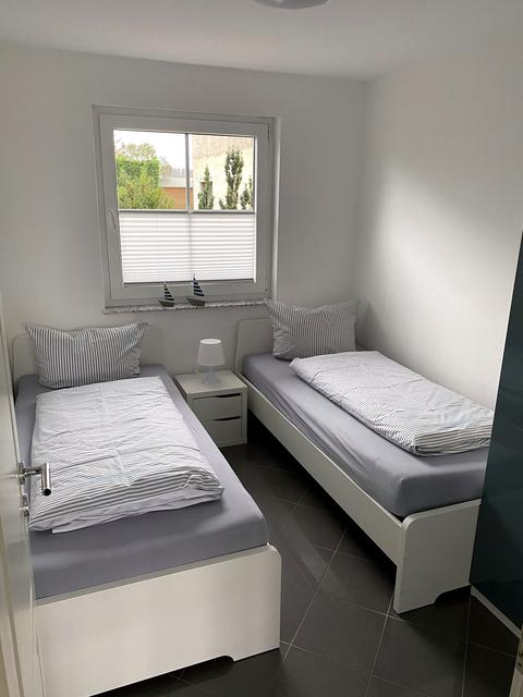 Helles Schlafzimmer mit zwei Einzelbetten und Kleiderschrank
