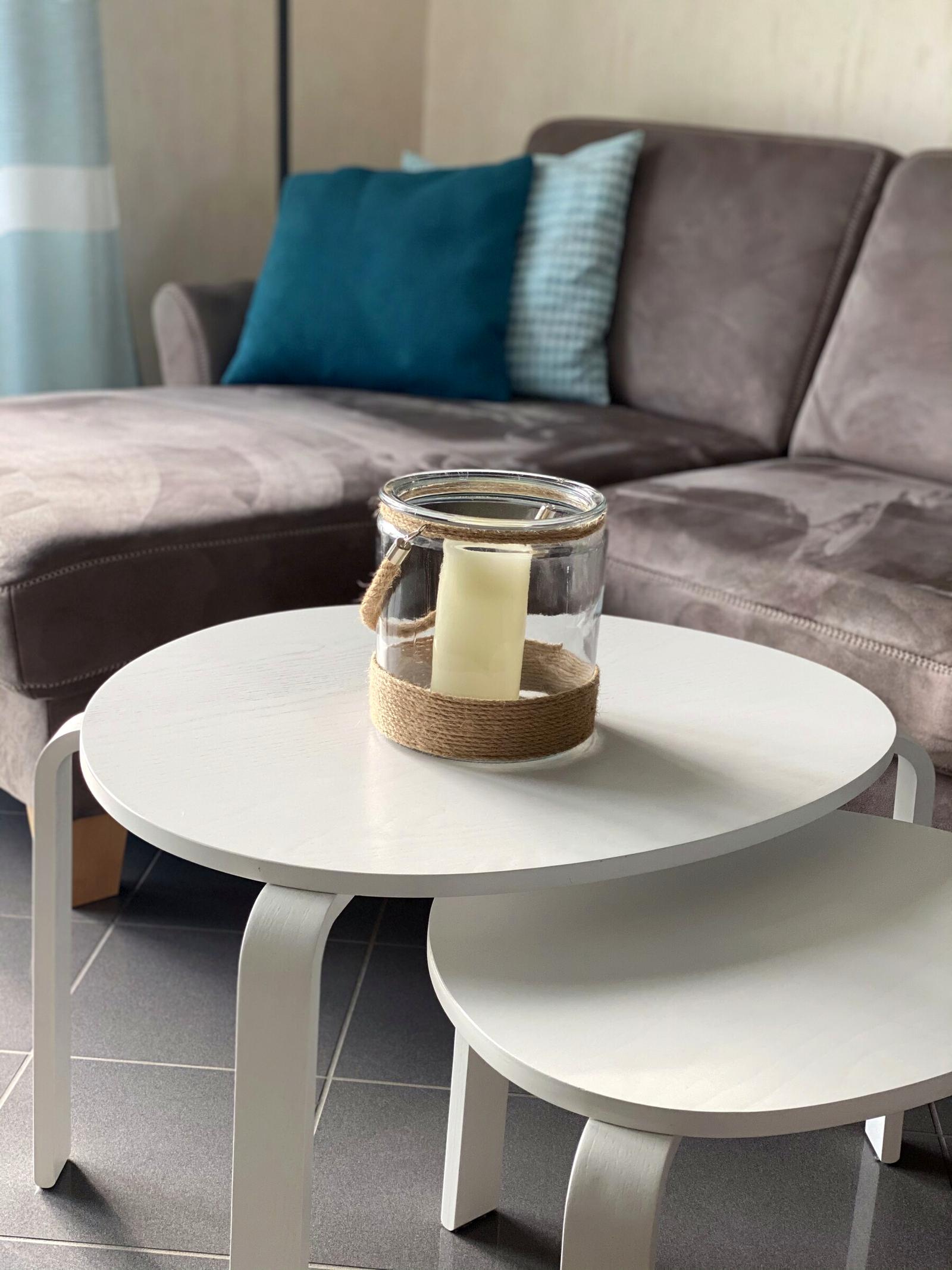 Gemütliches Ecksofa mit petrolfarbenen Kissen und Couchtisch